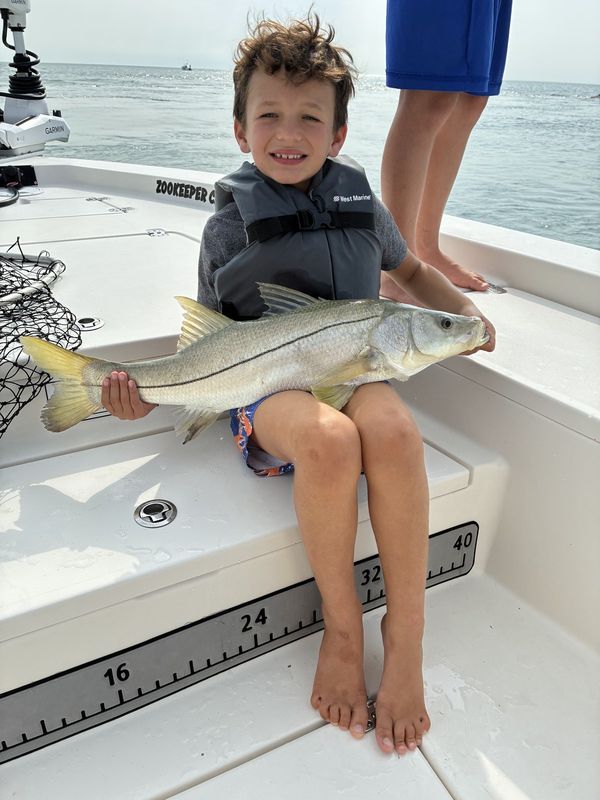 Young angler with a snook on a kids fishing trip